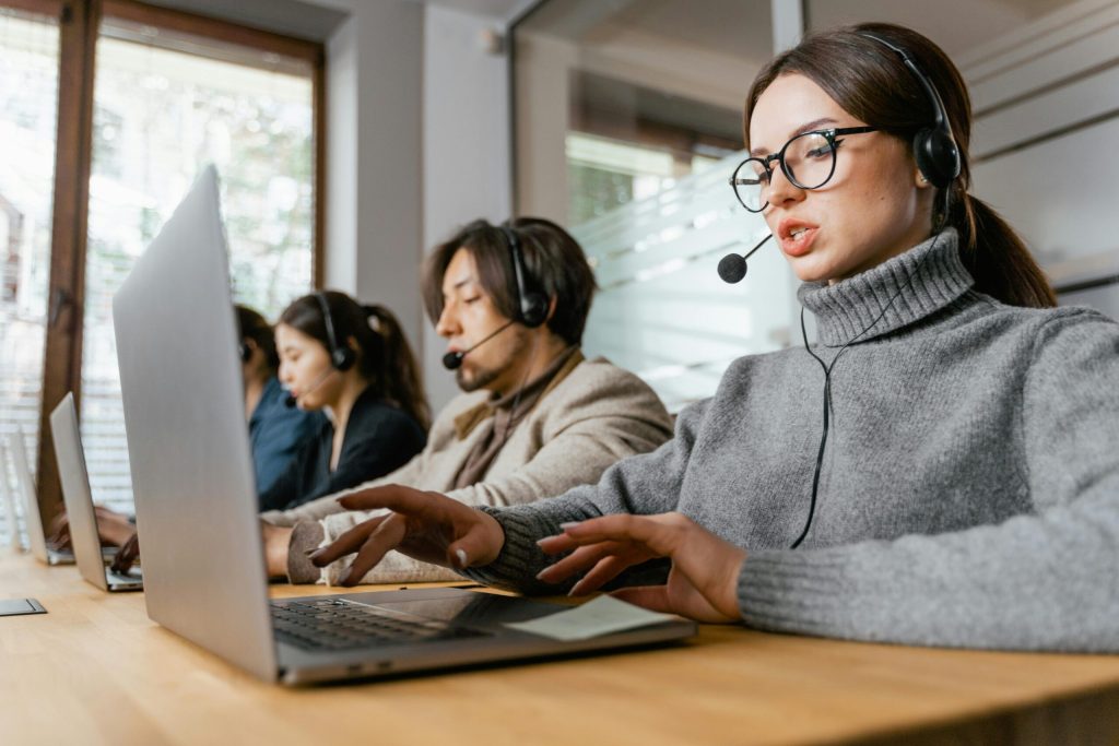 Woman at a computer workstation with a headset engaged in remote learning